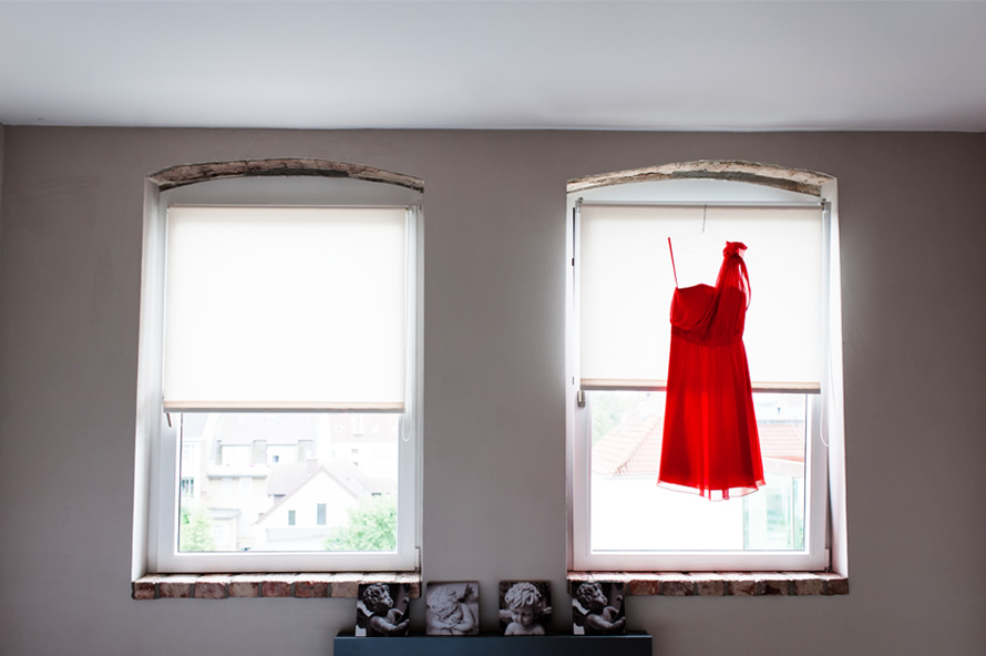 Rotes Hochzeitskleid am Fenster